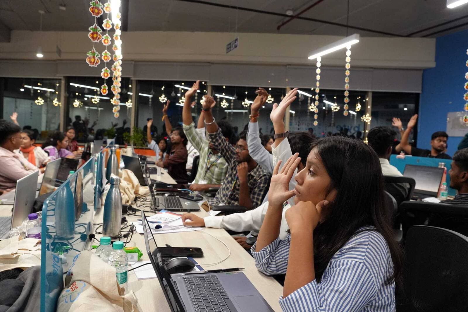 Participants raising their hands during a session on the coding floor